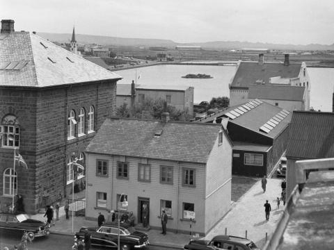 Líkn á sinni upprunalegu staðsetning við hlið Alþingishússins, tjörnin í baksýn. 